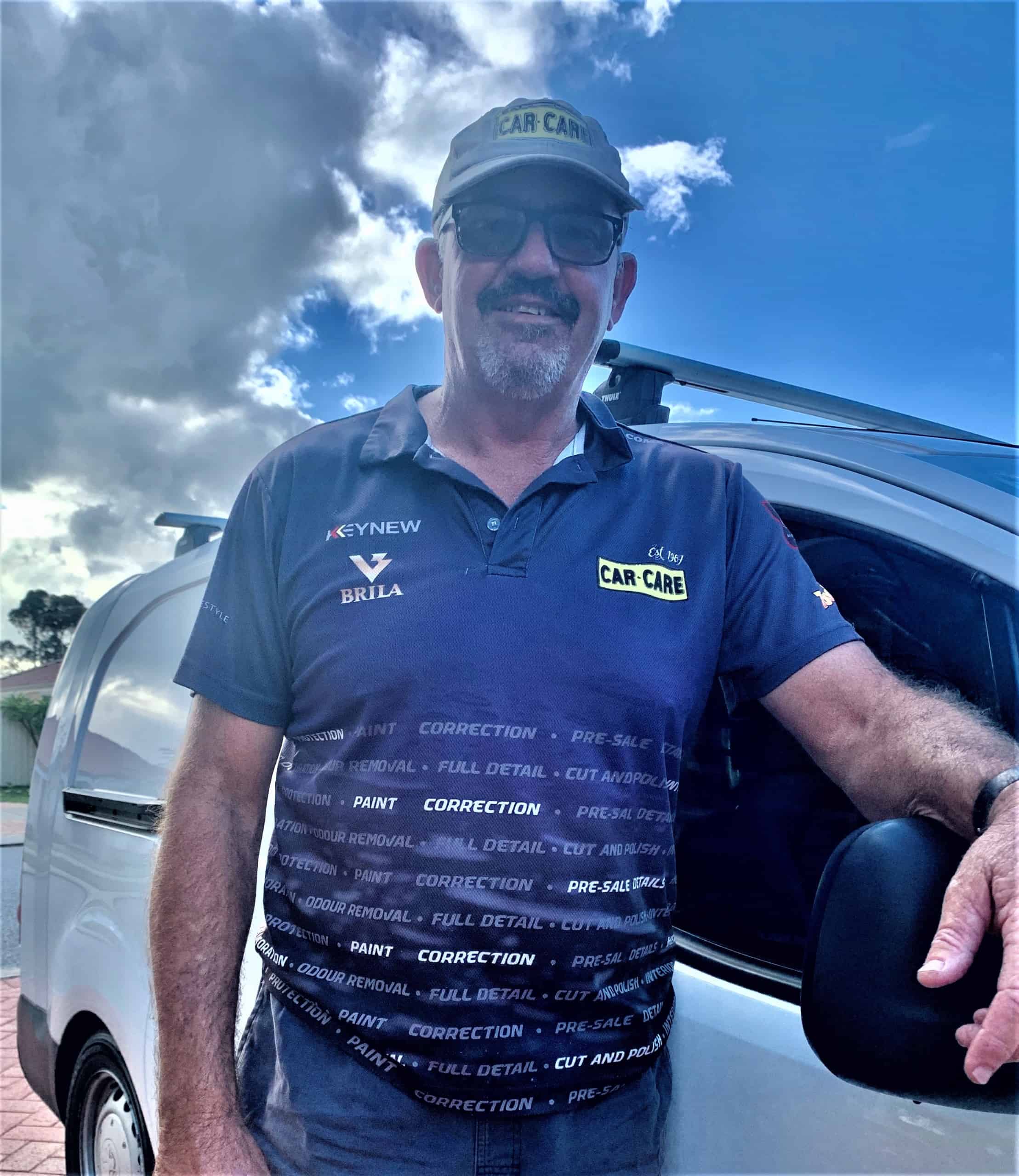 Greg Car Care Fremantle-Mandurah in front of white car